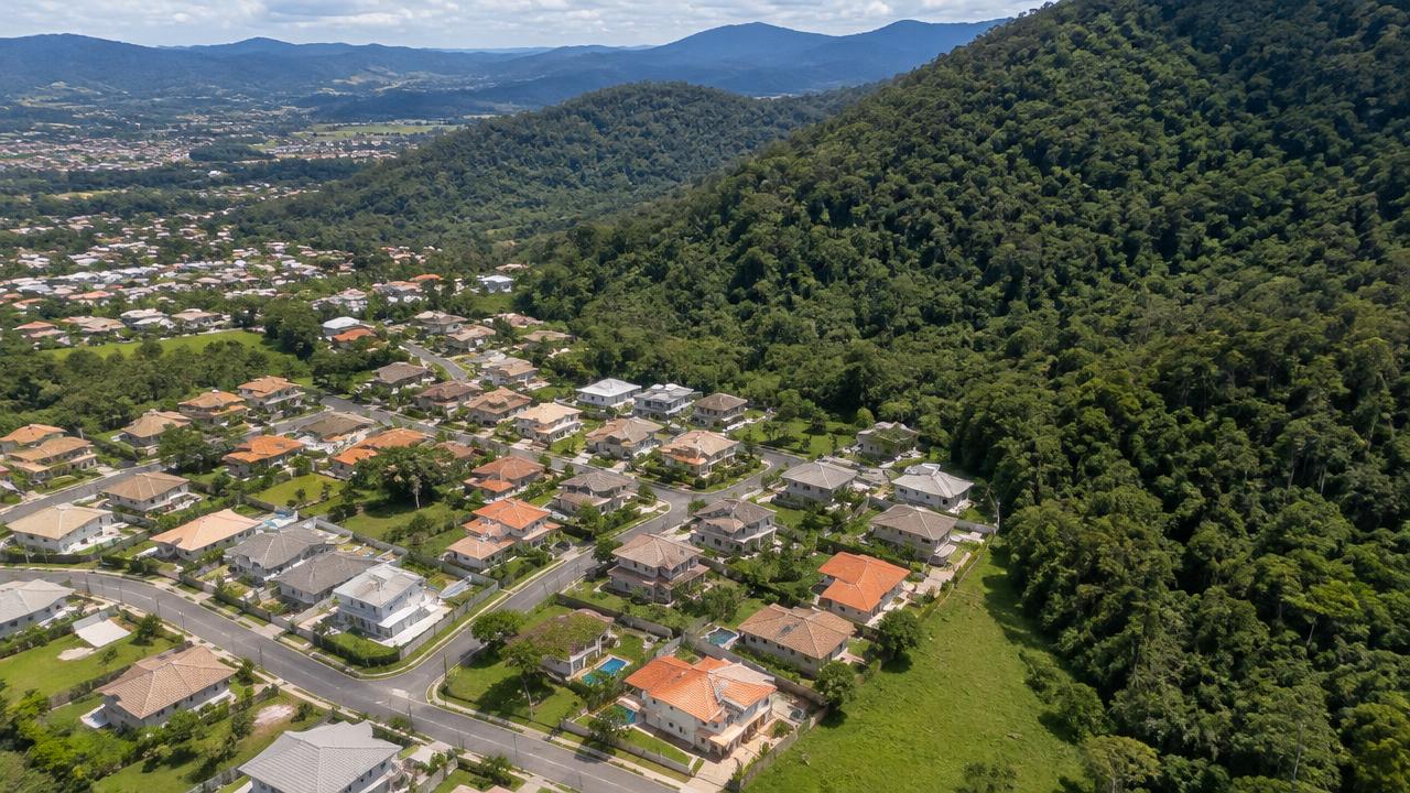Vista aérea de loteamento residencial junto a área de mata